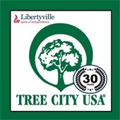 A dark green border matches the logo of a green in a circle in the center of the image. Text reads "Tree City USA - 30 years."