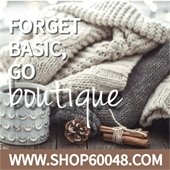 A cozy blanket sits on a wood floor next to a mug, a pinecone, and a bundle of cinnamon sticks. Text reads "Forget basic, go boutique - www.Shop60048.com."
