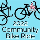 The background is bright light blue. Black outlines of two bicycles are at the top behind a logo in the shape of an L designed like an American flag. Beneath the logo is the word "Libertyville." Black text with a white shadow says "2022 Community Bike Ride."