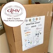 A drop-off box with a sign of logos reads "Winter Coat Drive." In the corner is a red logo in a circle that says "GLMV - Lake County's Most Active Chamber."