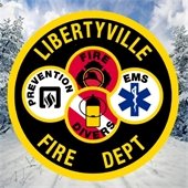 The Libertyville Fire Department badge sits in front of a scene of the snowy outdoors.