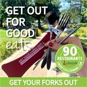 A hand with red nail polish is holding a spoon, fork, pair of chopsticks, and red carrying case in front of a park. White text reads "Get out for good eats." There is a lime green bar at the bottom of the image that says "Get your forks out" in white. A lime green circle logo is on top of the hand and says "90 restaurants - LibertyvilleDining.com."