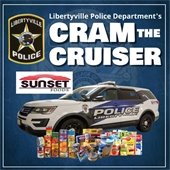 A police SUV is surrounded by canned goods on a blue background outlining a police badge. Text says "Libertyville Police Department's Cram the Cruiser."