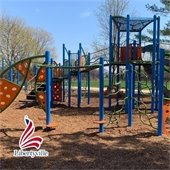 A blue and orange playground with woodchips on a sunny day.