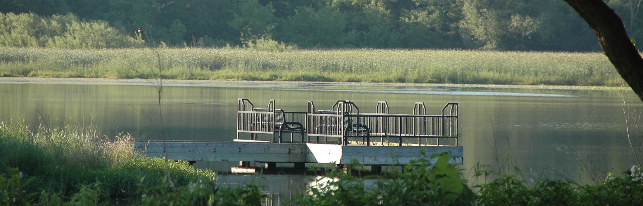 Round wooden river dock with benches at the park
